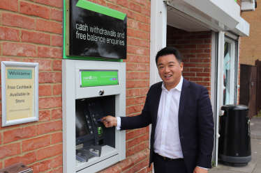 Local MP Alan Mak withdraws cash from the free-to-use machine on Snowberry Crescent.